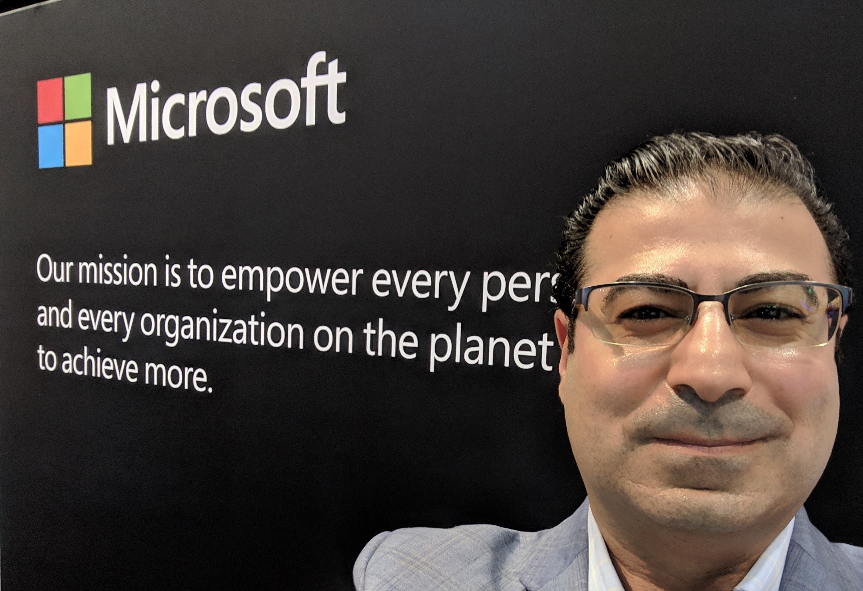 Man standing in front of Microsoft logo and tag line.